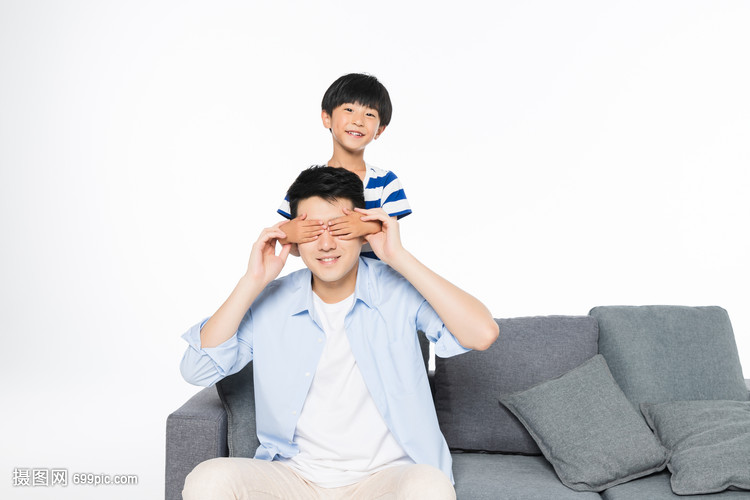 沙发上孩子蒙住父亲的眼睛