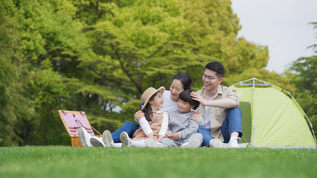 4k家庭出游一家人坐在草地上开心的聊天视频素材