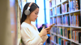 4k图书馆听音乐的女生视频素材