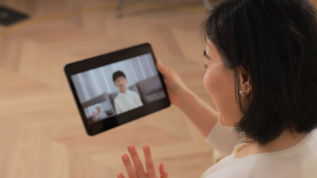 居家使用平板视频通话的中年女性视频素材