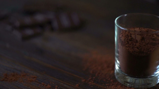 黑巧克力棒和木制桌上玻璃中的可粉视频素材