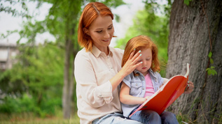 年轻母亲与女儿一起在户外阅读视频素材