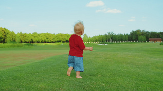 金发小子在绿草地玩得开心视频素材