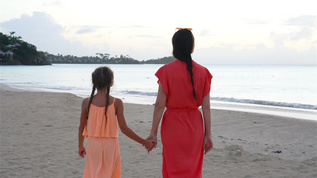 年轻的年轻美丽的母亲和可爱的小女儿在热带海滩玩得开心视频素材