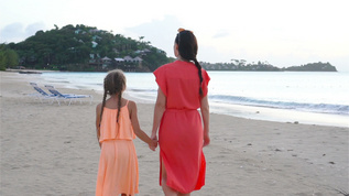 年轻的年轻美丽的母亲和可爱的小女儿在海滩玩得开心视频素材