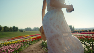 带着相机和草帽的年轻女子在美丽的郁金香花园里转来转去视频素材