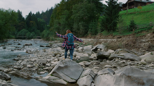 背着包的妇女站在山河边视频素材