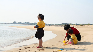 妈妈带孩子在海边玩沙子视频素材