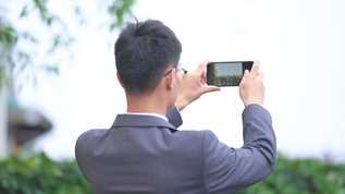 4k商务男性使用手机拍照视频素材