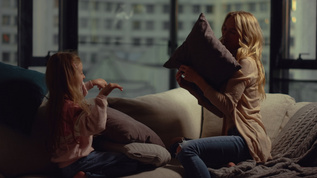 快乐的母亲和女儿用枕头打耍视频素材