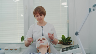 美容师在美容院给女人脸上涂奶油面罩视频素材