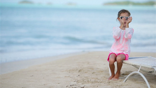 快乐的小女孩手里拿着玩具飞机在白色的沙滩上孩子在沙滩视频素材