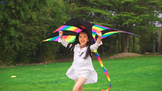 小女孩拿着风筝在草地上跑视频素材