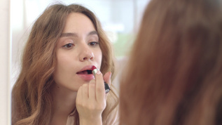 美丽的女人在家里用口红做唇膏化妆 前面的浴室镜子视频素材