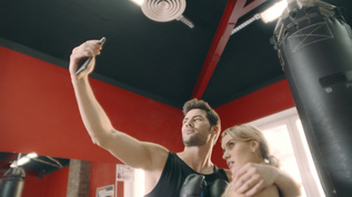 快乐的情侣拥抱 在健身房的移动自拍视频素材