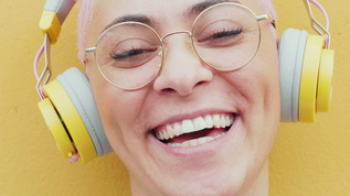 意大利戴着耳机和眼镜的微笑年轻女子肖像视频素材