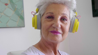 戴着耳机微笑的老妇人的肖像视频素材