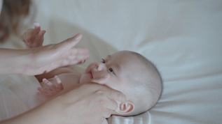 4k妈妈给婴儿宝宝按摩小脸餐身体乳视频素材