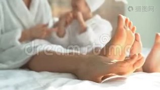洗澡后，可爱的妈妈和可爱的女儿穿着白大褂坐在床上踢我的腿mov格式视频下载_正版视频编号543759-摄图网