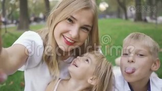 漂亮的高加索女人和她的两个孩子看着镜头微笑。 女人和孩子自拍。 小男孩，女孩mp4格式视频下载_正版视频编号2845600-摄图网
