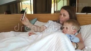 一位母亲和一个小儿子在床上躺在电话上自拍mov格式视频下载_正版视频编号1646901-摄图网