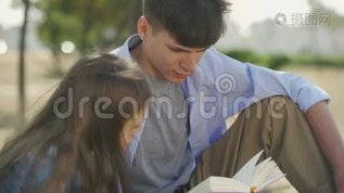 男孩和他的小妹妹在阳光明媚的秋日里坐在公园里看诗或故事的书的肖像。mp4格式视频下载_正版视频编号3450461-摄图网