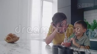 年轻的妈妈和儿子在厨房里用糖果喝果汁。 快乐的母亲和儿子慢慢地坐在桌子上mov格式视频下载_正版视频编号2775466-摄图网