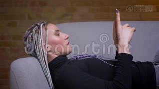 年轻迷人的白种人潮女的特写镜头，用平板电脑转向相机，开心地微笑着躺着mov格式视频下载_正版视频编号2324246-摄图网