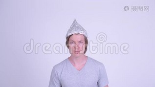 戴锡箔帽的年轻人的脸看上去很震惊mov格式视频下载_正版视频编号2926430-摄图网