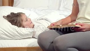 可爱的小女孩在床上大笑，她的母亲在睡觉前给她读了一本书mov格式视频下载_正版视频编号826959-摄图网