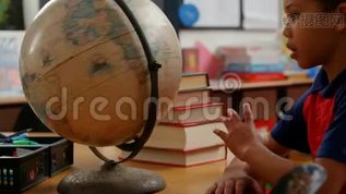 非裔美国小学生4k教室课桌学习地球仪的侧视图mov格式视频下载_正版视频编号1576940-摄图网