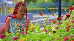 红头发的女人欣赏公园里美丽的花朵。mov格式视频下载_正版视频编号2175521-摄图网