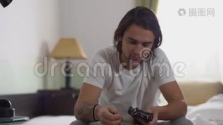 年轻的帅哥坐在床上看着汽车玩具和小男孩在床上扔枕头。mp4格式视频下载_正版视频编号1427614-摄图网