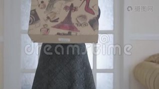 可爱的女孩眨眼站在客厅，手拿购物袋在她的肩膀上。 在镜头里看的女人mp4格式视频下载_正版视频编号1278099-摄图网