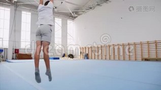 一个十几岁的男孩正在健身房里做一个手推车和三个后翻，Steadicam。mov格式视频下载_正版视频编号2930002-摄图网
