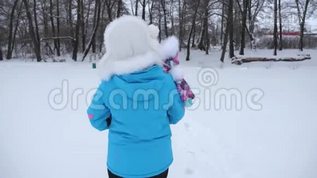 妈妈怀里抱着一个幸福的小女儿，走在一条下雪的路上。 宝宝和妈妈在冬天散步。 儿童mp4格式视频下载_正版视频编号2101690-摄图网