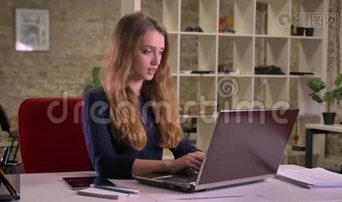 忙碌的白种人女商人在办公室里用笔记本电脑工作的肖像在平板电脑上收到通知。视频下载-实拍视频-正版视频353115-摄图网