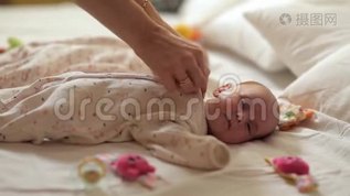 妈妈从孩子身上脱衣服，从出生的第一天开始为新生儿做特殊的体操。 儿童`mov格式视频下载_正版视频编号2557719-摄图网