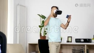 男人在客厅玩虚拟现实游戏，而她的女朋友在电脑上工作mov格式视频下载_正版视频编号2180708-摄图网