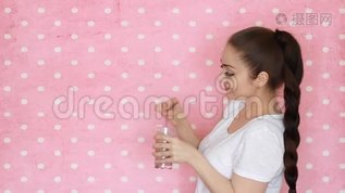 美丽的快乐女孩喝水果或浆果冰沙。 年轻女子在粉红色背景下拿着一杯mov格式视频下载_正版视频编号2863315-摄图网