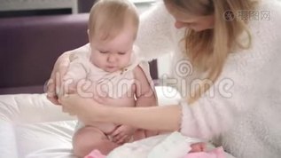 妈妈给宝宝脱衣服。去散步的婴儿。婴儿床上用品mov格式视频下载_正版视频编号2938380-摄图网