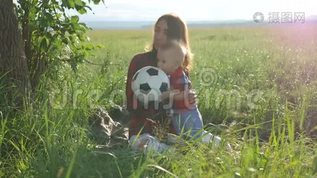 妈妈和她的小儿子正坐在公园的草地上玩足球。 幸福的家庭mp4格式视频下载_正版视频编号1511388-摄图网