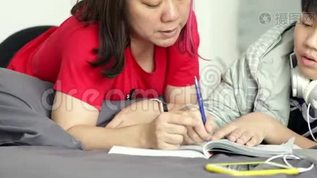 当男孩在家做家庭作业时，亚洲母亲帮助他的小儿子mov格式视频下载_正版视频编号1590113-摄图网