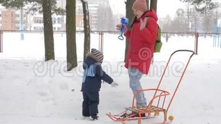 可爱的小男孩和年轻的母亲在冬天和公园里的雪玩耍。 蓝色的孩子`夹克和红色的妈妈。mov格式视频下载_正版视频编号223347-摄图网