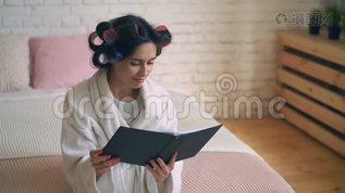 洗完澡后的女孩穿着带有卷发器的浴衣，在电话上交流。mp4格式视频下载_正版视频编号3317654-摄图网