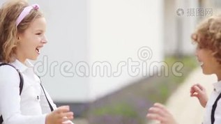 会见两名学童，一名男孩和一名女孩。 孩子们互相问候。 回学校去。 在学校第一次mov格式视频下载_正版视频编号514323-摄图网