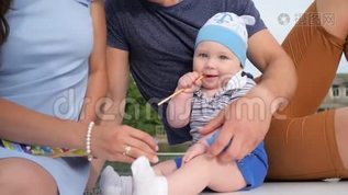 可爱的婴儿坐在户外休息的父母旁边，孩子在游艇上从妈妈手`拿玩具，mp4格式视频下载_正版视频编号1593711-摄图网