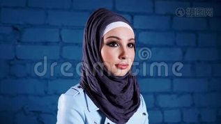 一个漂亮的现代穆斯林女人戴着头巾的肖像，看上去很好奇mov格式视频下载_正版视频编号1669073-摄图网