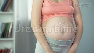 怀着小女孩的孕妇，抱着粉红色的鞋子在腹部附近，婴儿淋浴mov格式视频下载_正版视频编号1669608-摄图网