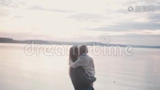 年轻的黑发女人抱着小男孩在海滩海岸。 母亲吻她的儿子，用手指指着地平线。mov格式视频下载_正版视频编号2572595-摄图网